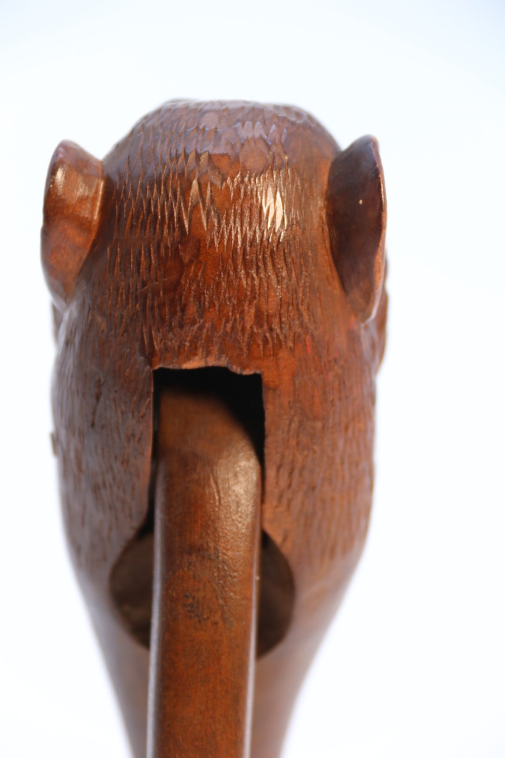 A hand-carved walnut nutcracker shaped as a monkey head with glass bead eyes and a hinged jaw mechanism. View XVIII
