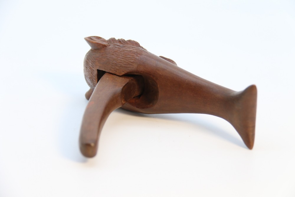 A hand-carved walnut nutcracker shaped as a monkey head with glass bead eyes and a hinged jaw mechanism. View XIX