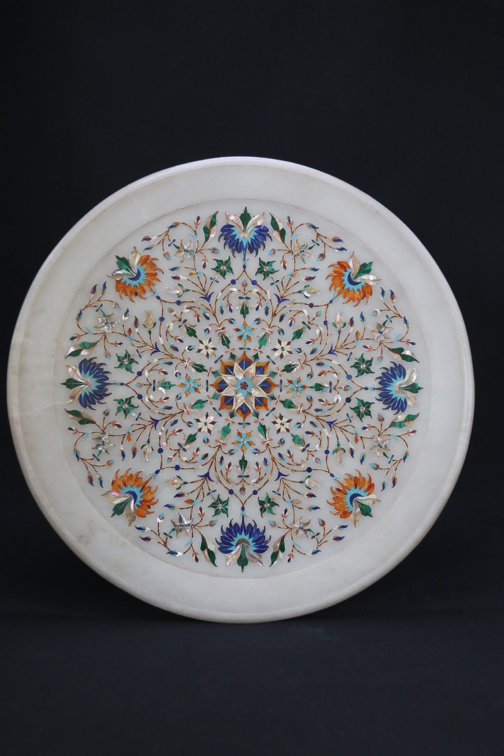 A rare and ultra-fine Raj period Indian white marble charger profusely inlaid with semi-precious cut stones.
