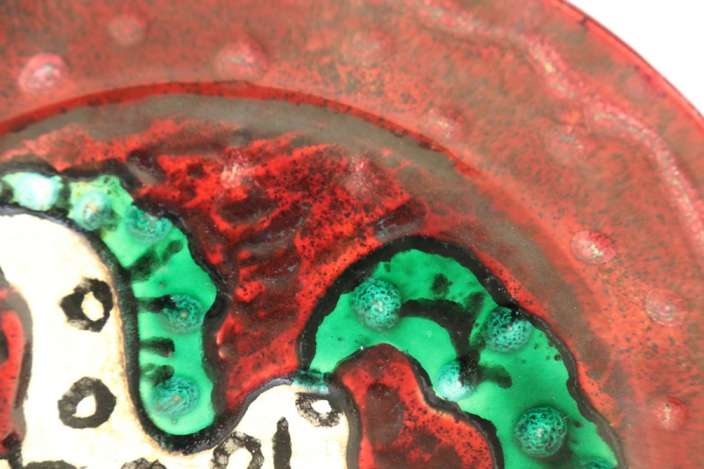 A circular glazed ceramic charger featuring a stylised cream horse motif against a deep red and emerald green reactive glaze. View II