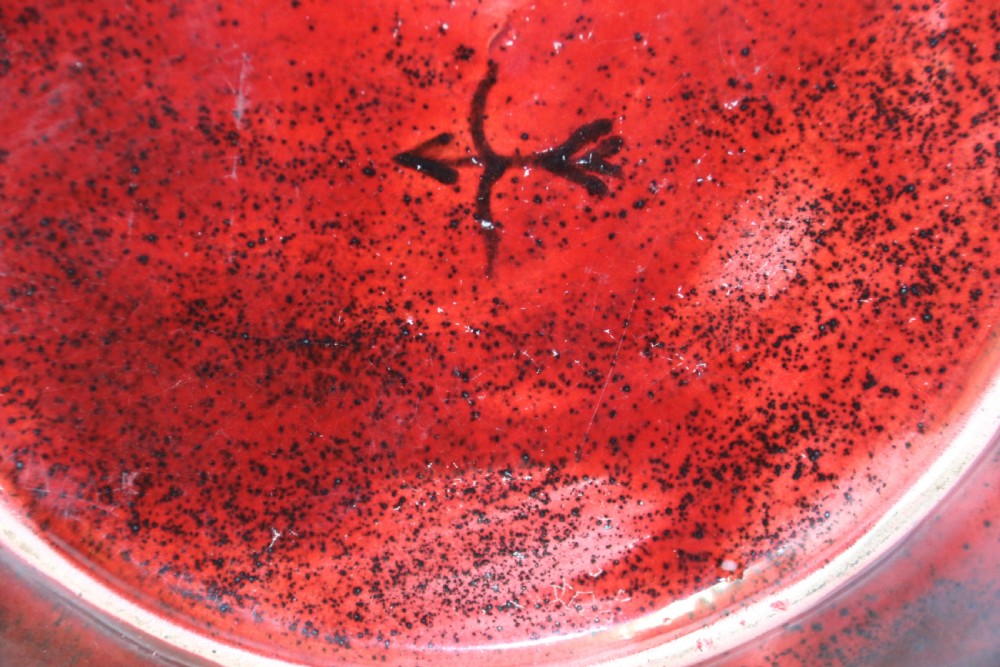 A circular glazed ceramic charger featuring a stylised cream horse motif against a deep red and emerald green reactive glaze. View X