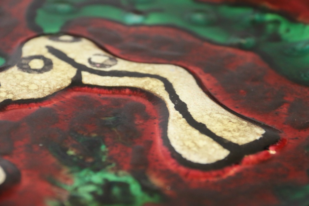 A circular glazed ceramic charger featuring a stylised cream horse motif against a deep red and emerald green reactive glaze. View XIII