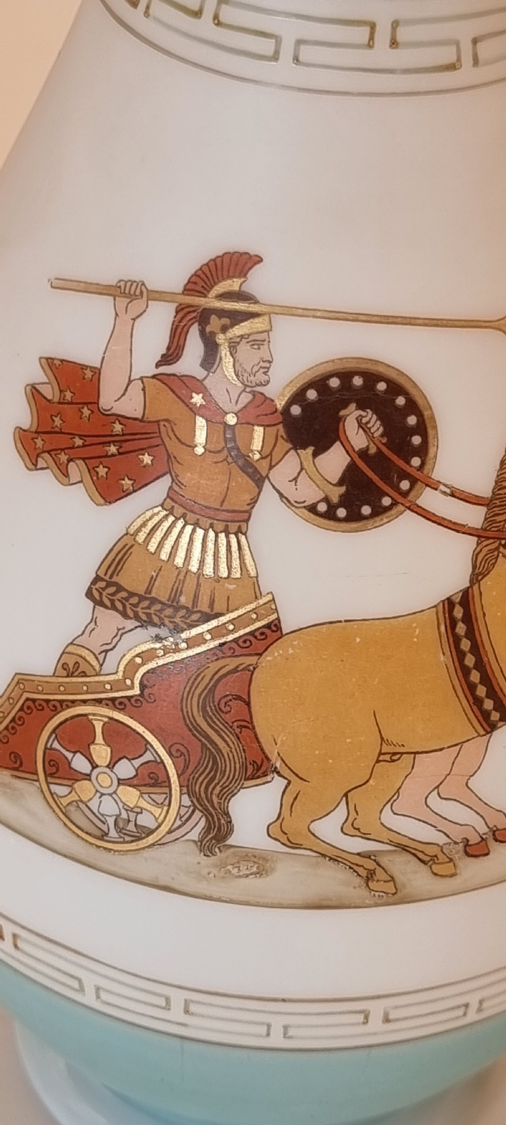 A late nineteenth-century opaque white and light blue glass vase decorated with a hand-painted scene of a Greek chariot and warrior bordered by Greek key patterns. View VIII