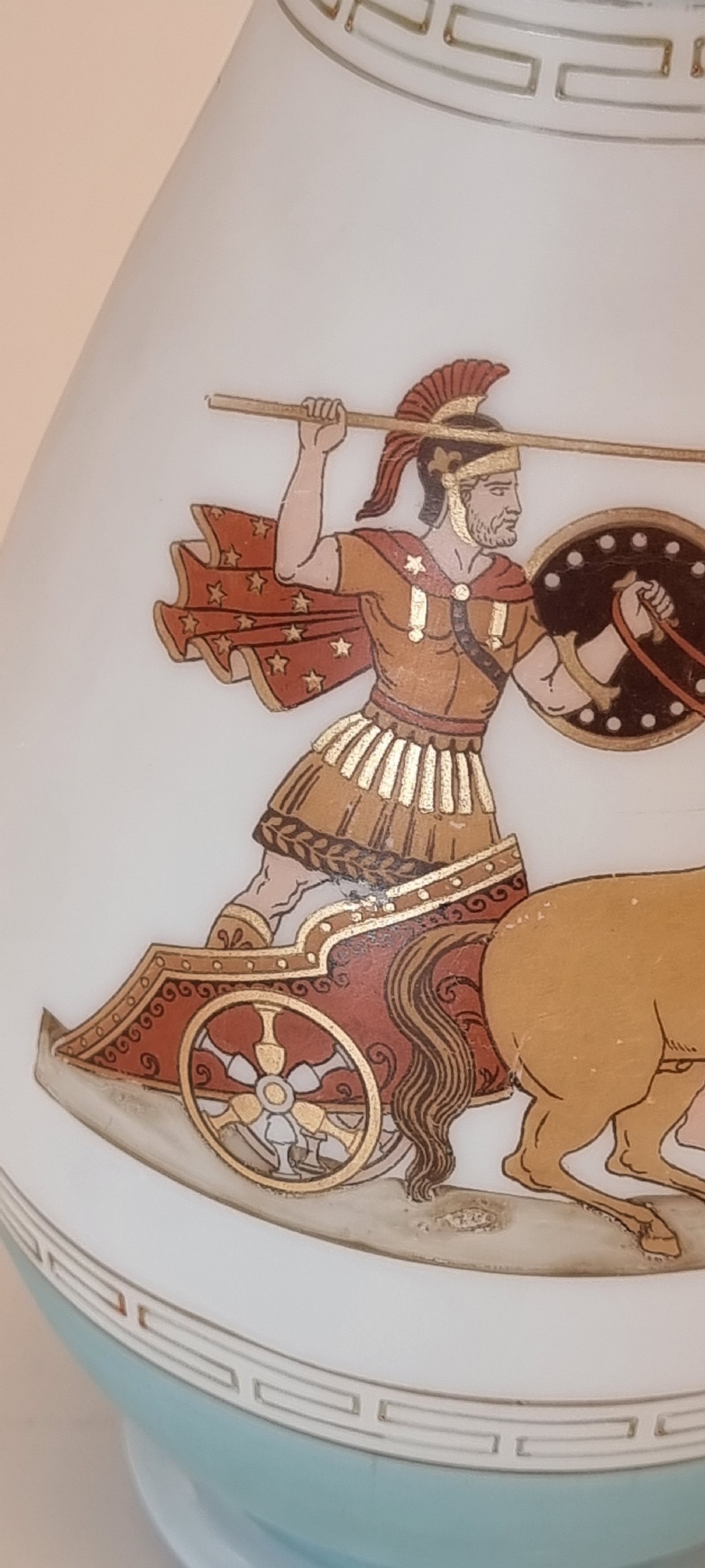 A late nineteenth-century opaque white and light blue glass vase decorated with a hand-painted scene of a Greek chariot and warrior bordered by Greek key patterns. View IX