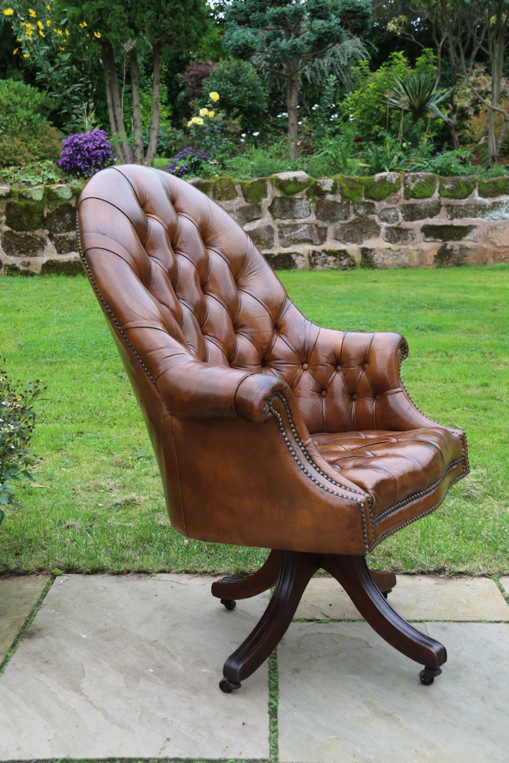 An English tilt and rotate desk/study armchair upholstered in original deep buttoned leather. View III
