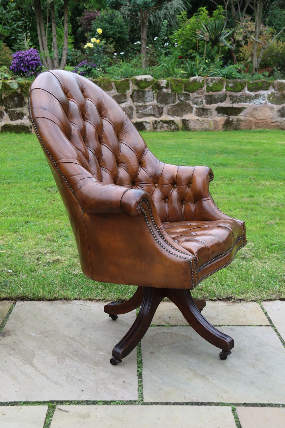 An English tilt and rotate desk/study armchair upholstered in original deep buttoned leather. View IV
