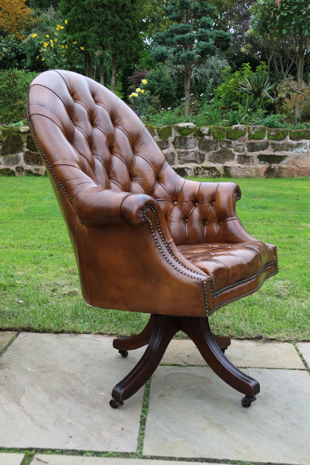An English tilt and rotate desk/study armchair upholstered in original deep buttoned leather. View V