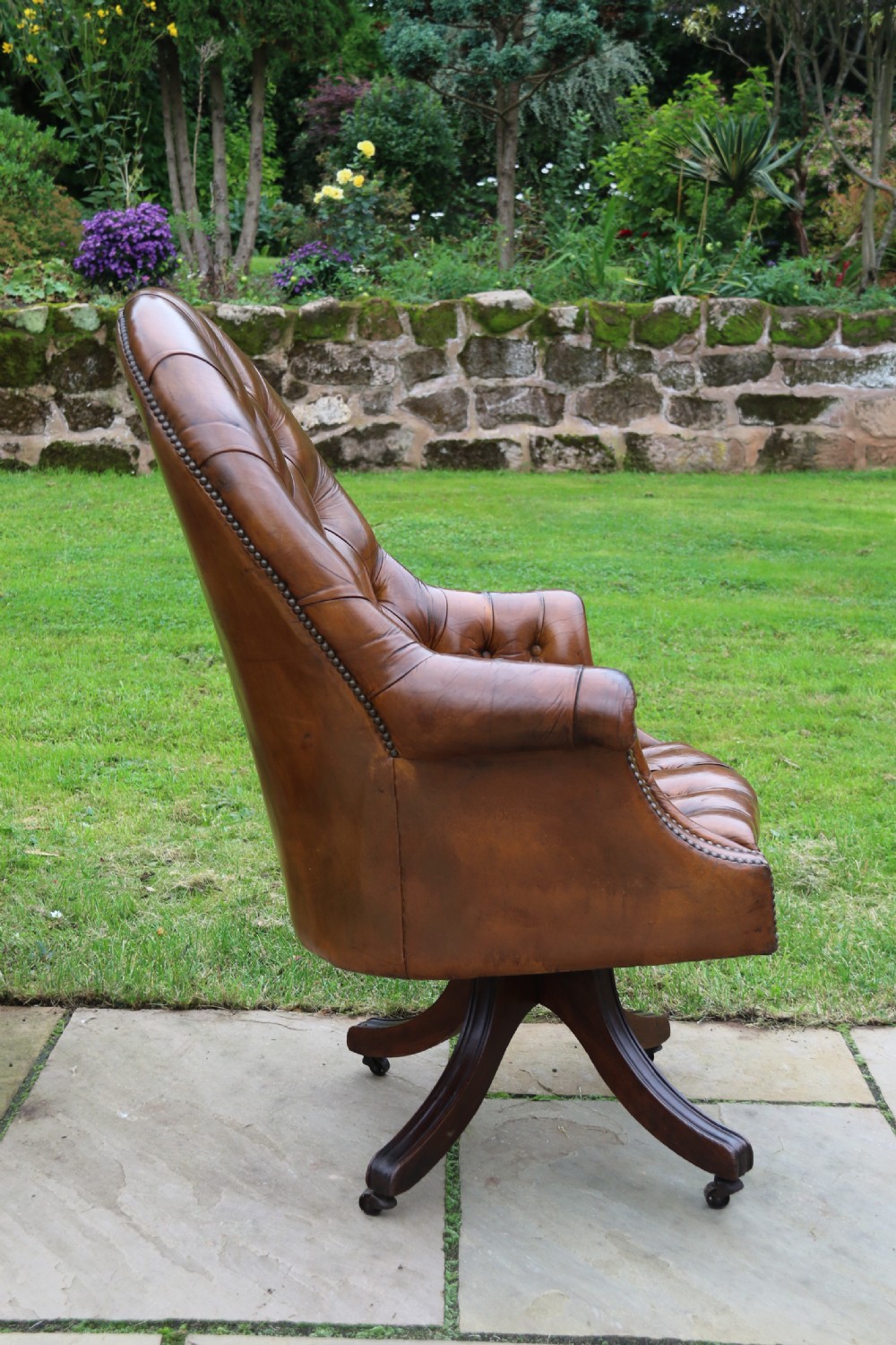 An English tilt and rotate desk/study armchair upholstered in original deep buttoned leather. View VI