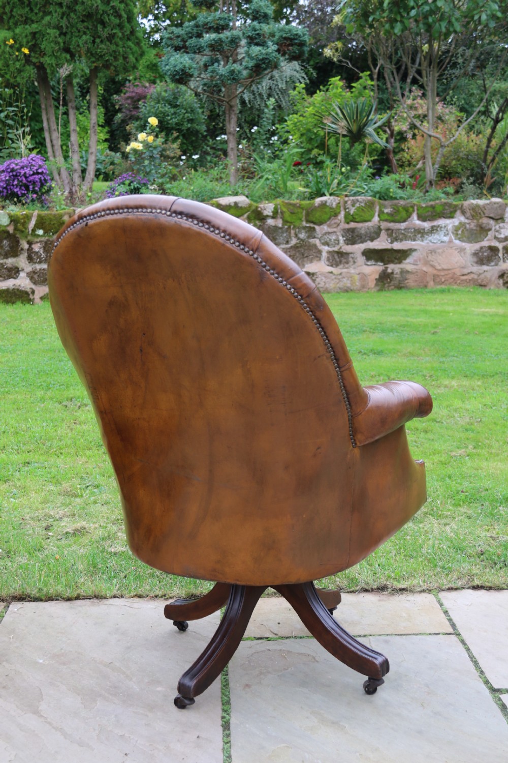 An English tilt and rotate desk/study armchair upholstered in original deep buttoned leather. View VII