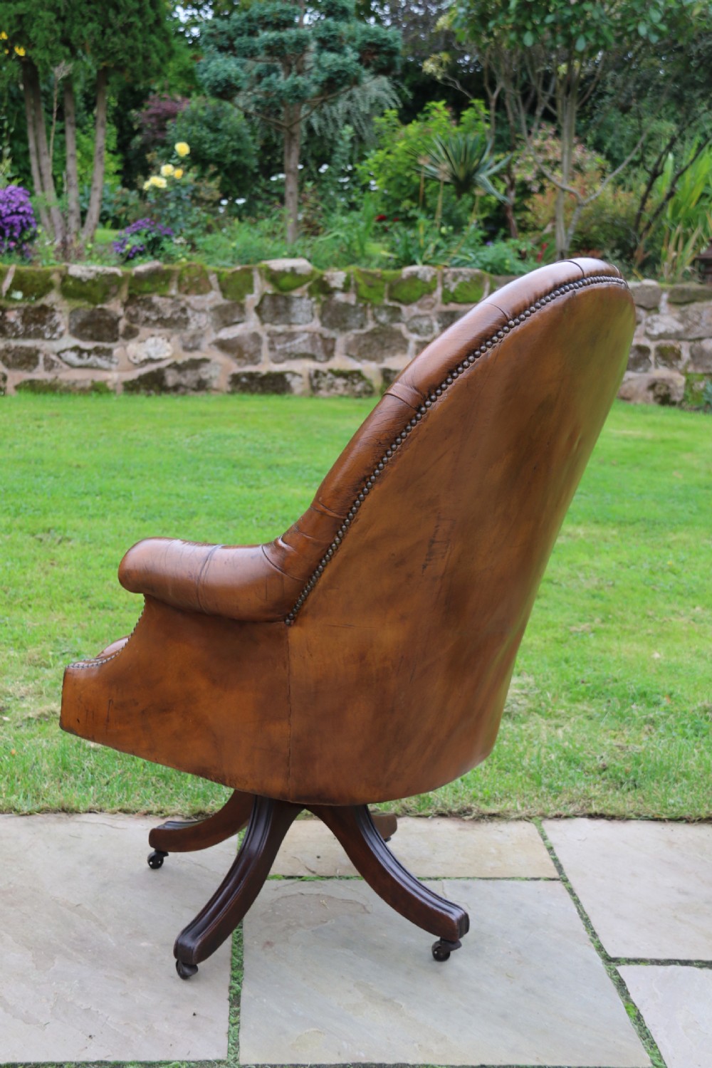 An English tilt and rotate desk/study armchair upholstered in original deep buttoned leather. View VIII