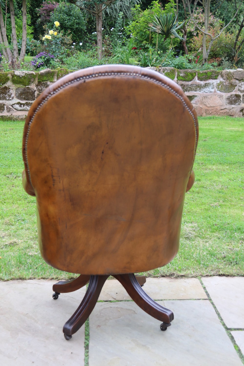 An English tilt and rotate desk/study armchair upholstered in original deep buttoned leather. View IX