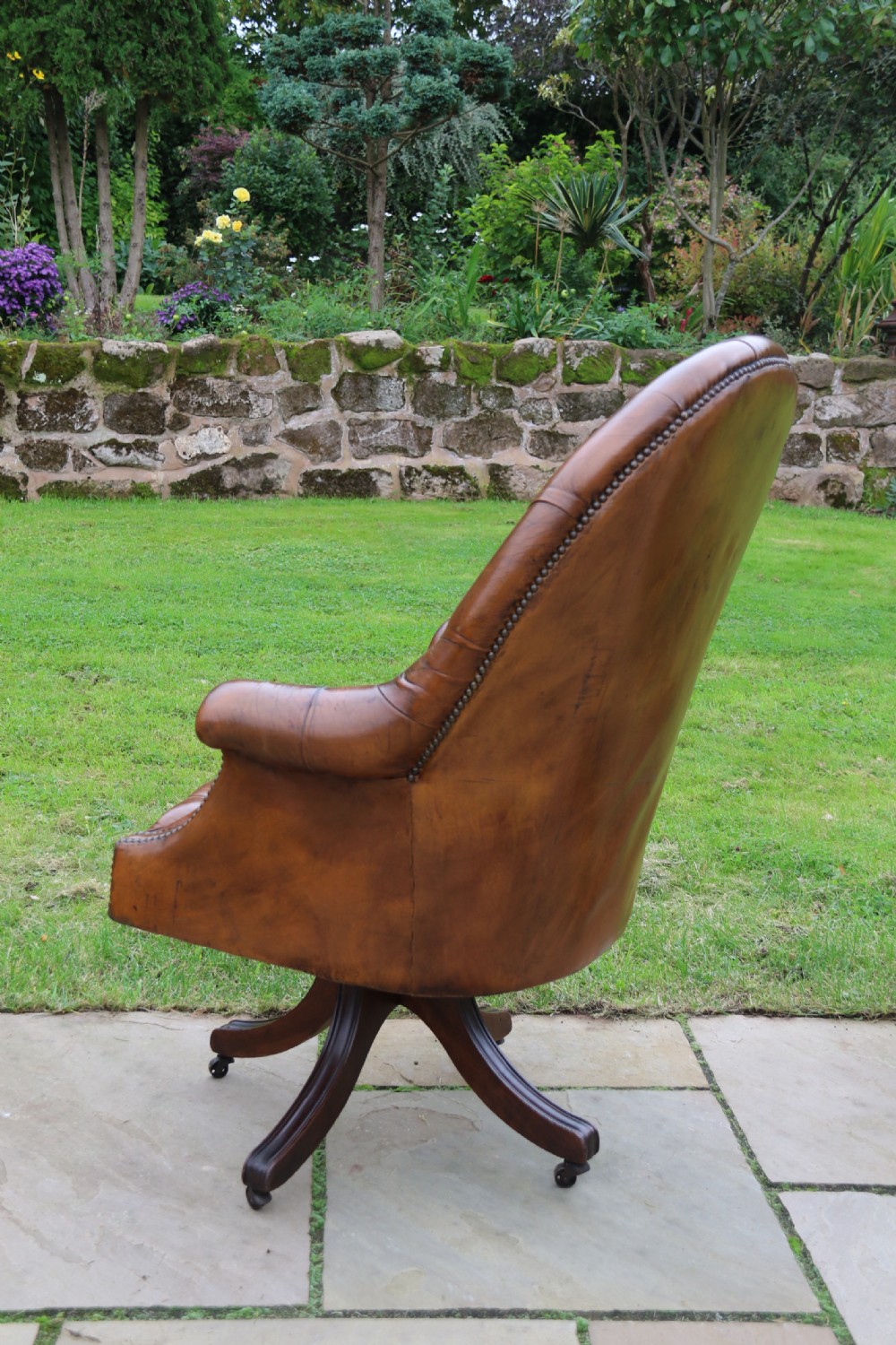 An English tilt and rotate desk/study armchair upholstered in original deep buttoned leather. View X