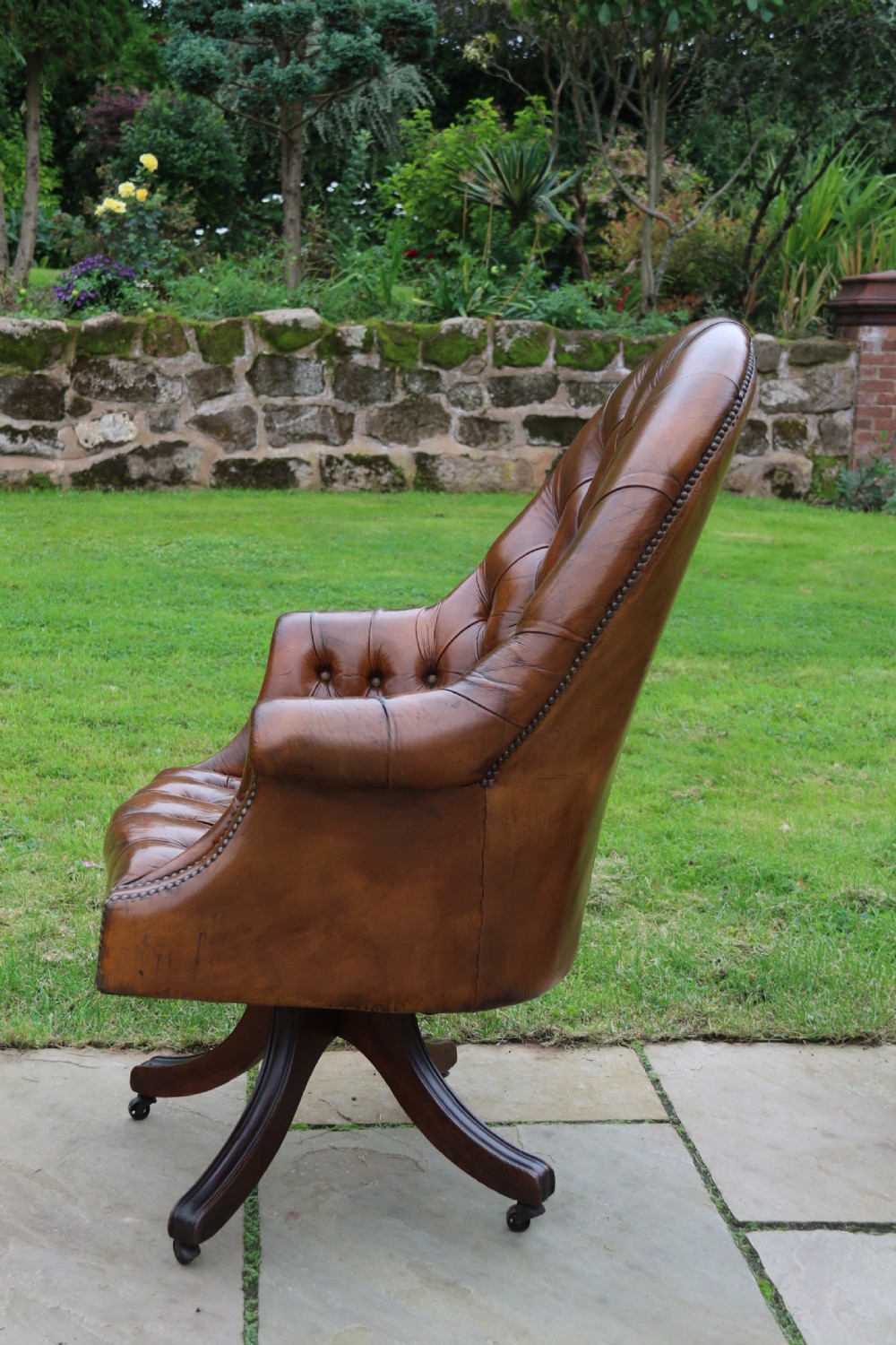 An English tilt and rotate desk/study armchair upholstered in original deep buttoned leather. View XI