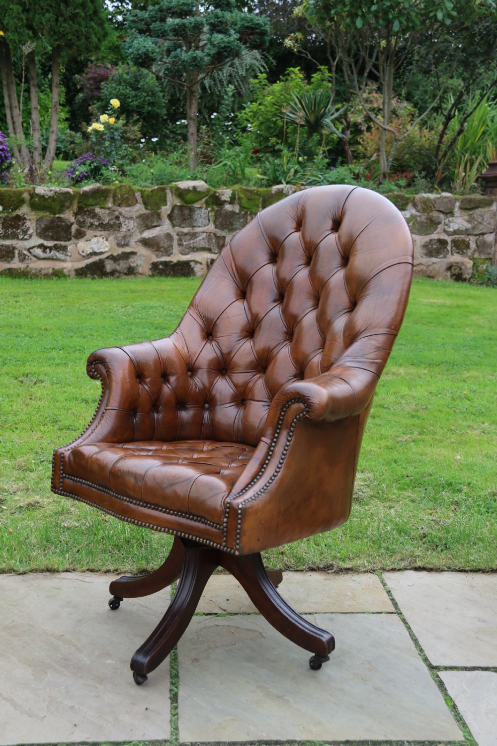 An English tilt and rotate desk/study armchair upholstered in original deep buttoned leather. View XII