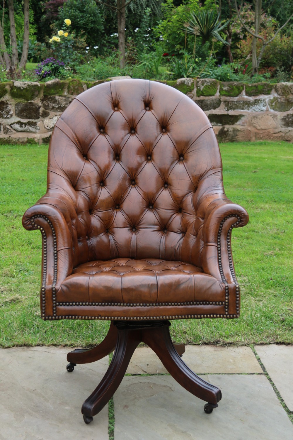 An English tilt and rotate desk/study armchair upholstered in original deep buttoned leather. View XIII