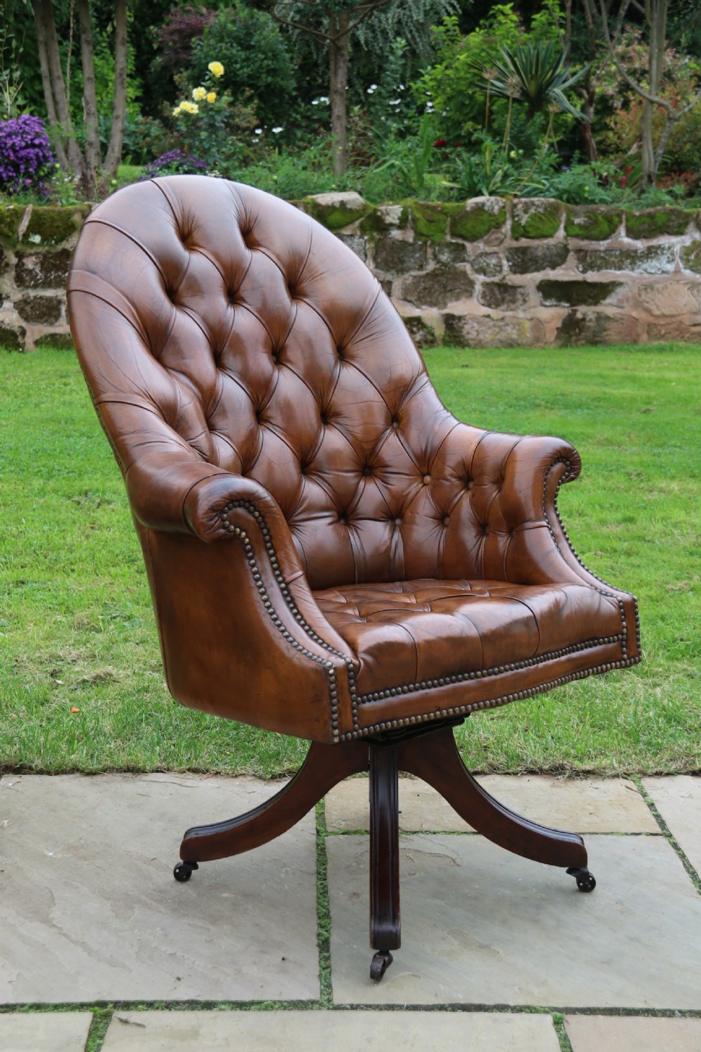 An English tilt and rotate desk/study armchair upholstered in original deep buttoned leather. View XIV