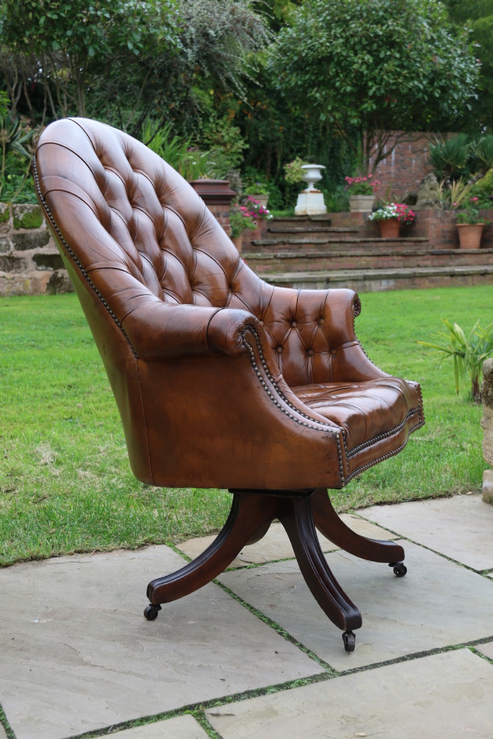 An English tilt and rotate desk/study armchair upholstered in original deep buttoned leather. View XV