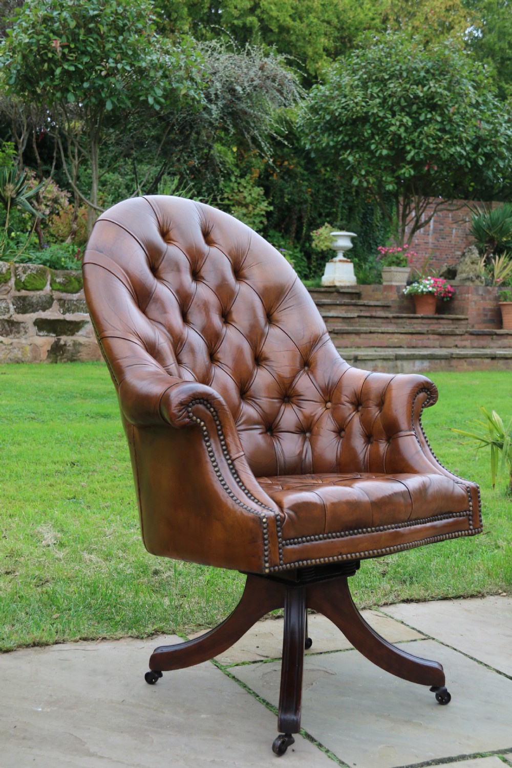 An English tilt and rotate desk/study armchair upholstered in original deep buttoned leather. View XVI