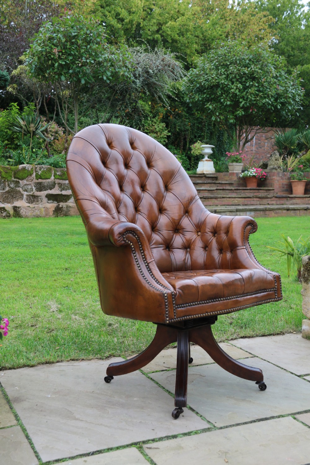 An English tilt and rotate desk/study armchair upholstered in original deep buttoned leather. View XVII
