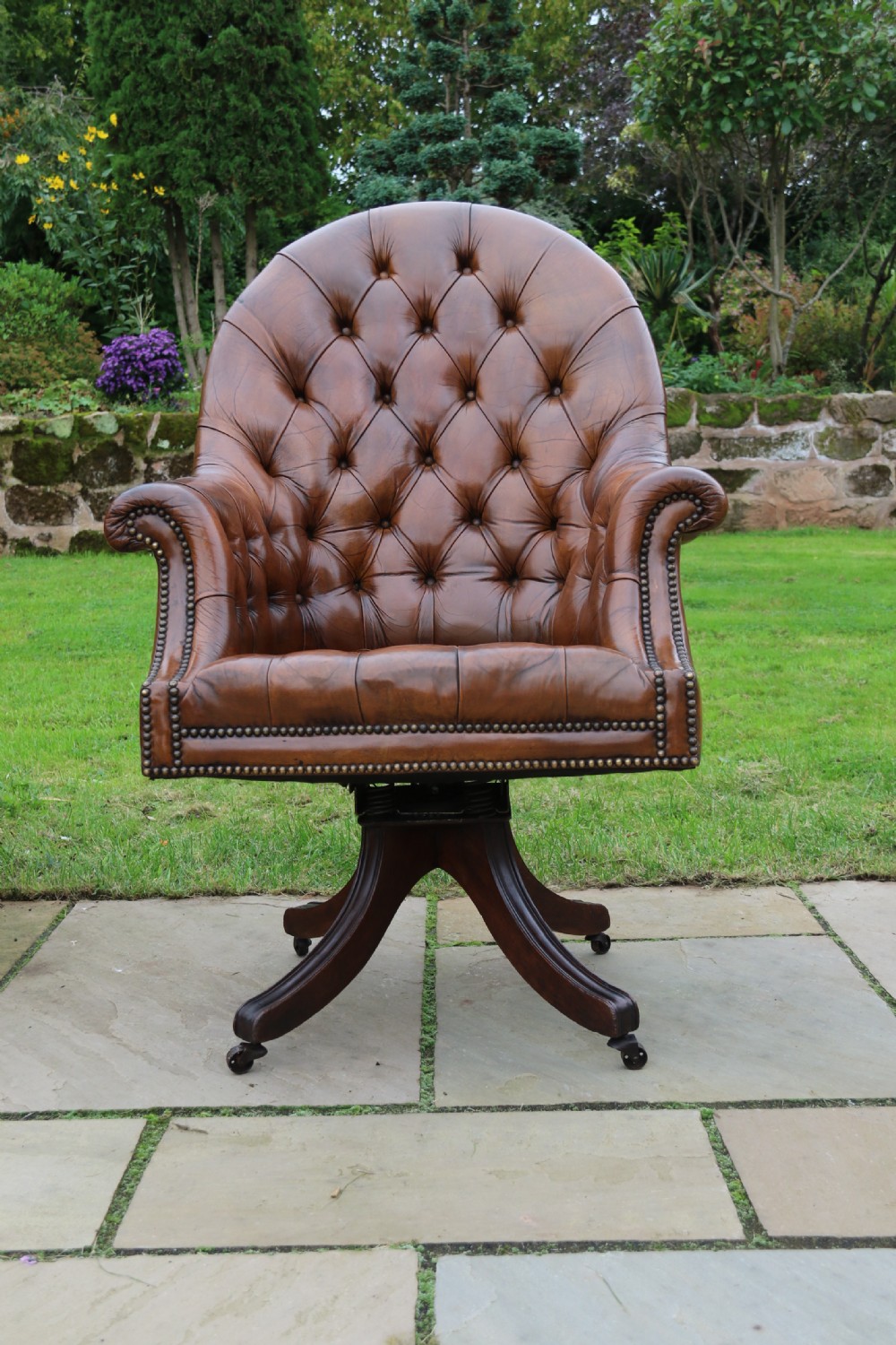 An English tilt and rotate desk/study armchair upholstered in original deep buttoned leather. View XVIII