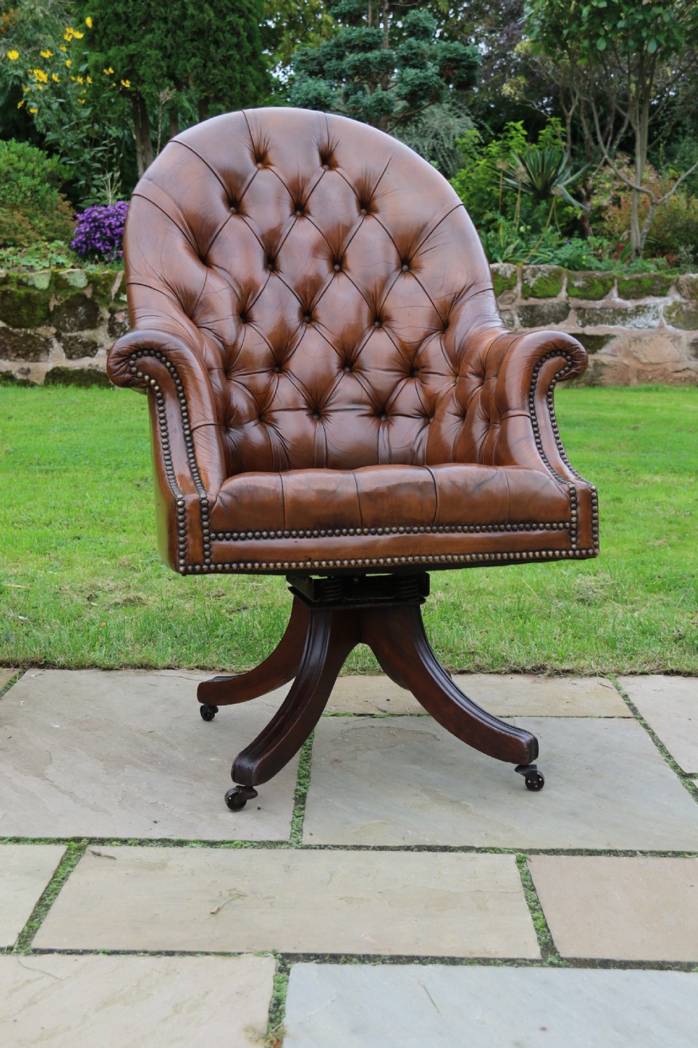 An English tilt and rotate desk/study armchair upholstered in original deep buttoned leather. View XIX