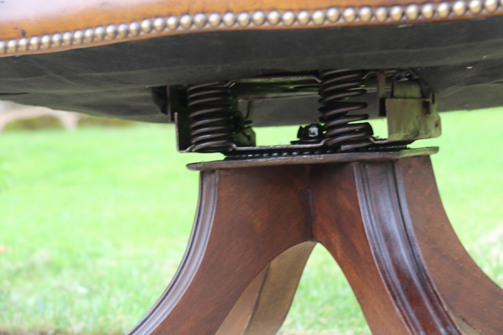 An English tilt and rotate desk/study armchair upholstered in original deep buttoned leather. View XX