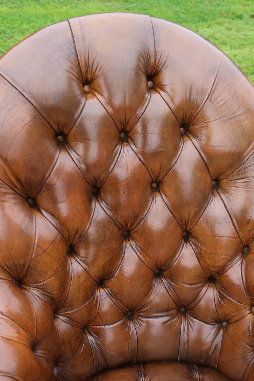 An English tilt and rotate desk/study armchair upholstered in original deep buttoned leather. View XXIV