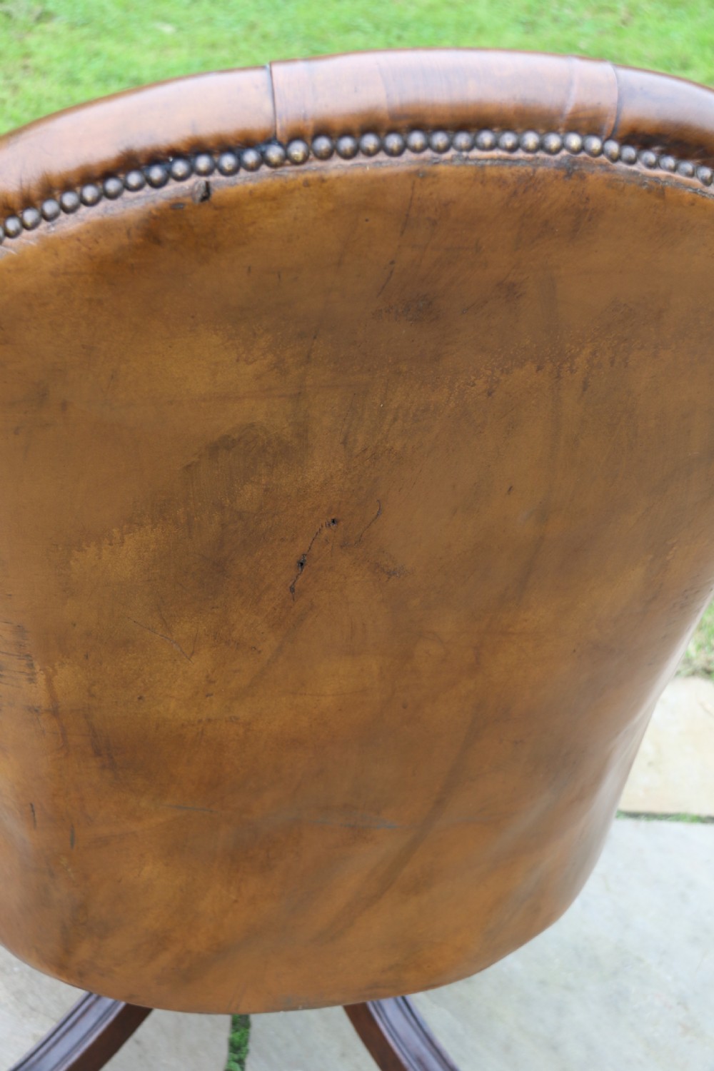 An English tilt and rotate desk/study armchair upholstered in original deep buttoned leather. View XXVIII