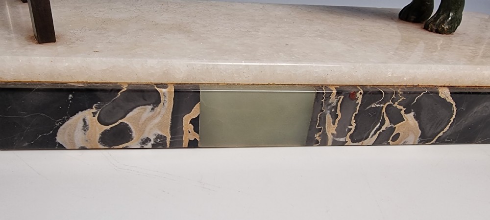 An Art Deco patinated bronze sculpture depicting a Russian borzoi hound leaping over a dark hurdle mounted on a two-tone marble base. View IX