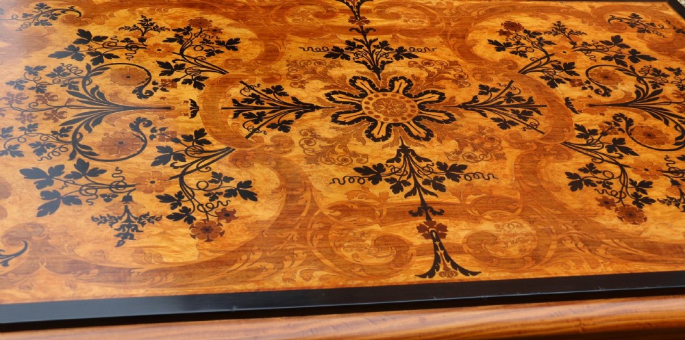 A rectangular mid-19th century satinwood centre table featuring detailed floral marquetry inlay across the tabletop, supported by carved barley twist legs and a central stretcher. View III