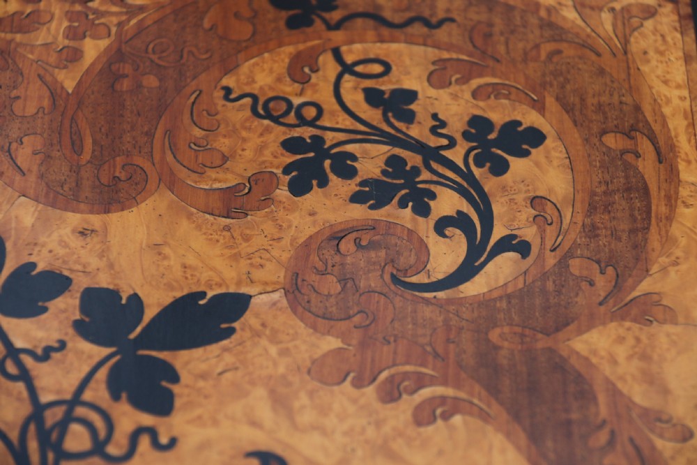 A rectangular mid-19th century satinwood centre table featuring detailed floral marquetry inlay across the tabletop, supported by carved barley twist legs and a central stretcher. View IV