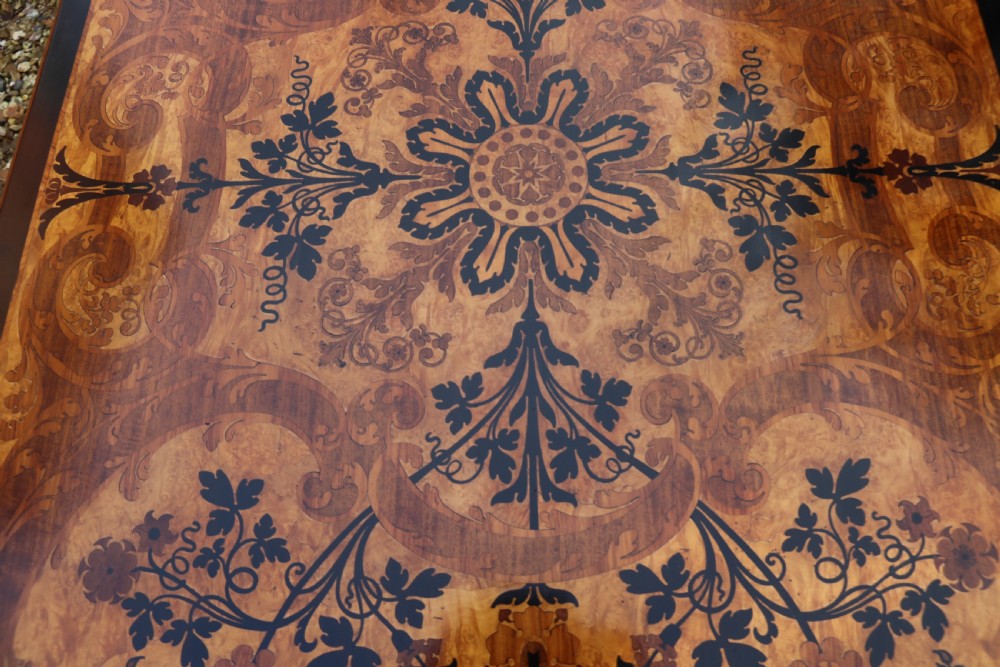 A rectangular mid-19th century satinwood centre table featuring detailed floral marquetry inlay across the tabletop, supported by carved barley twist legs and a central stretcher. View V