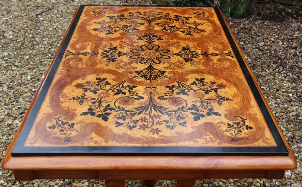 A rectangular mid-19th century satinwood centre table featuring detailed floral marquetry inlay across the tabletop, supported by carved barley twist legs and a central stretcher. View VI