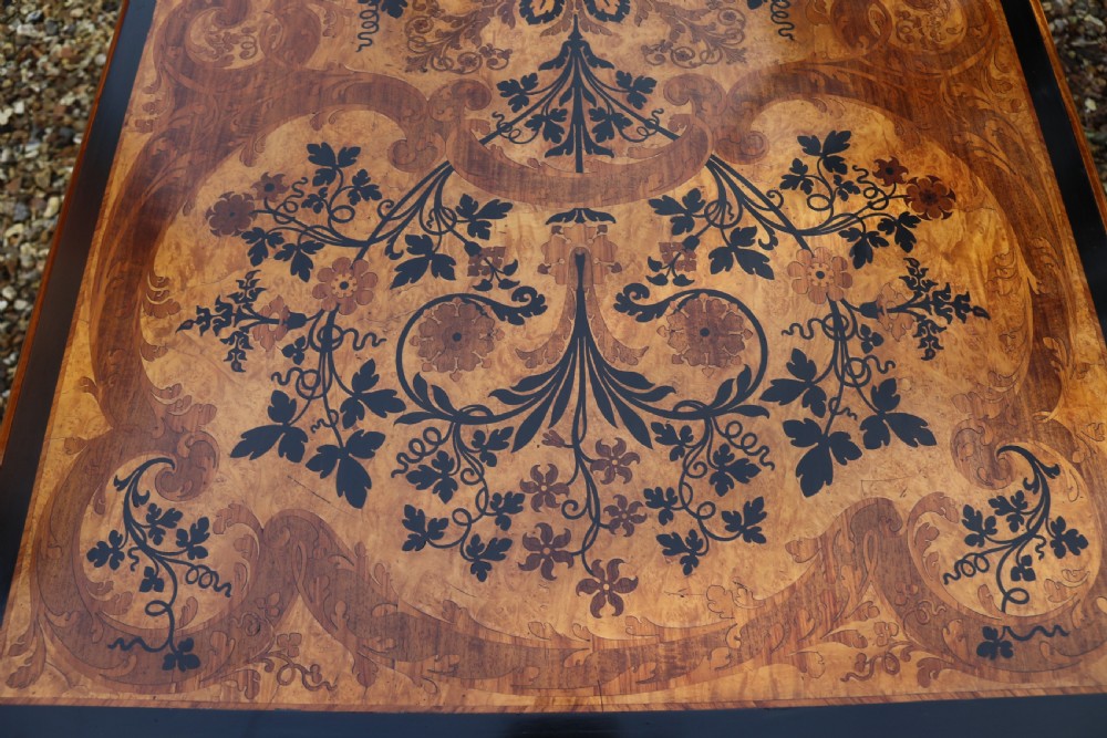 A rectangular mid-19th century satinwood centre table featuring detailed floral marquetry inlay across the tabletop, supported by carved barley twist legs and a central stretcher. View IX