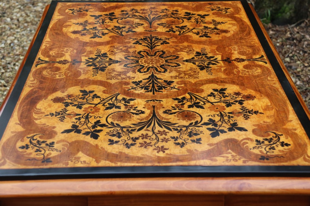 A rectangular mid-19th century satinwood centre table featuring detailed floral marquetry inlay across the tabletop, supported by carved barley twist legs and a central stretcher. View XIV