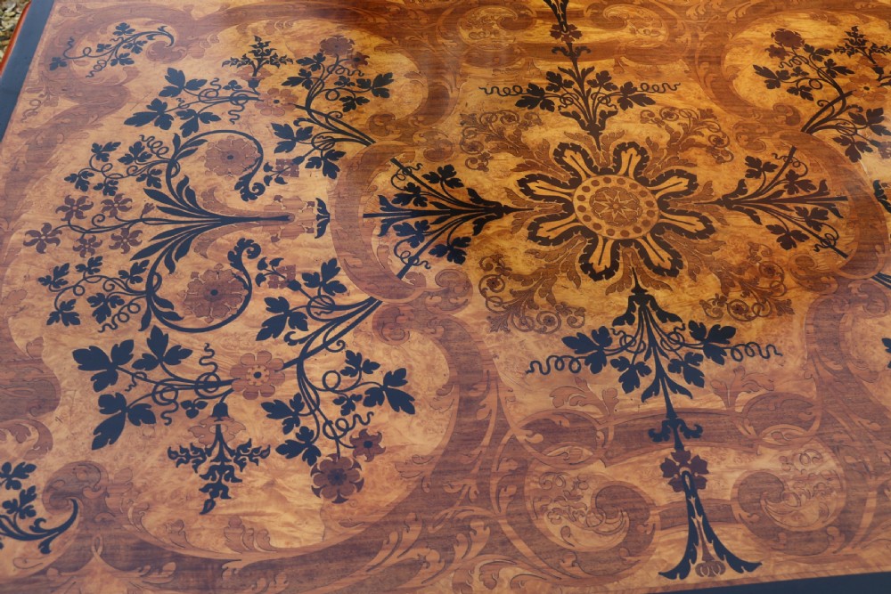 A rectangular mid-19th century satinwood centre table featuring detailed floral marquetry inlay across the tabletop, supported by carved barley twist legs and a central stretcher. View XV