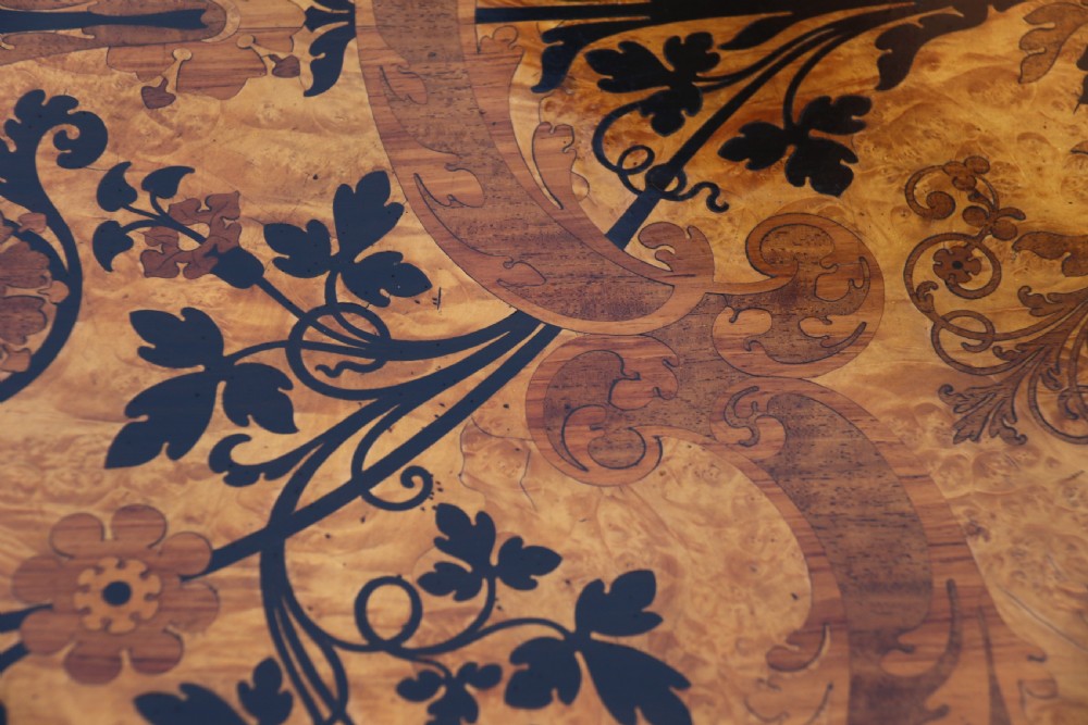 A rectangular mid-19th century satinwood centre table featuring detailed floral marquetry inlay across the tabletop, supported by carved barley twist legs and a central stretcher. View XVI