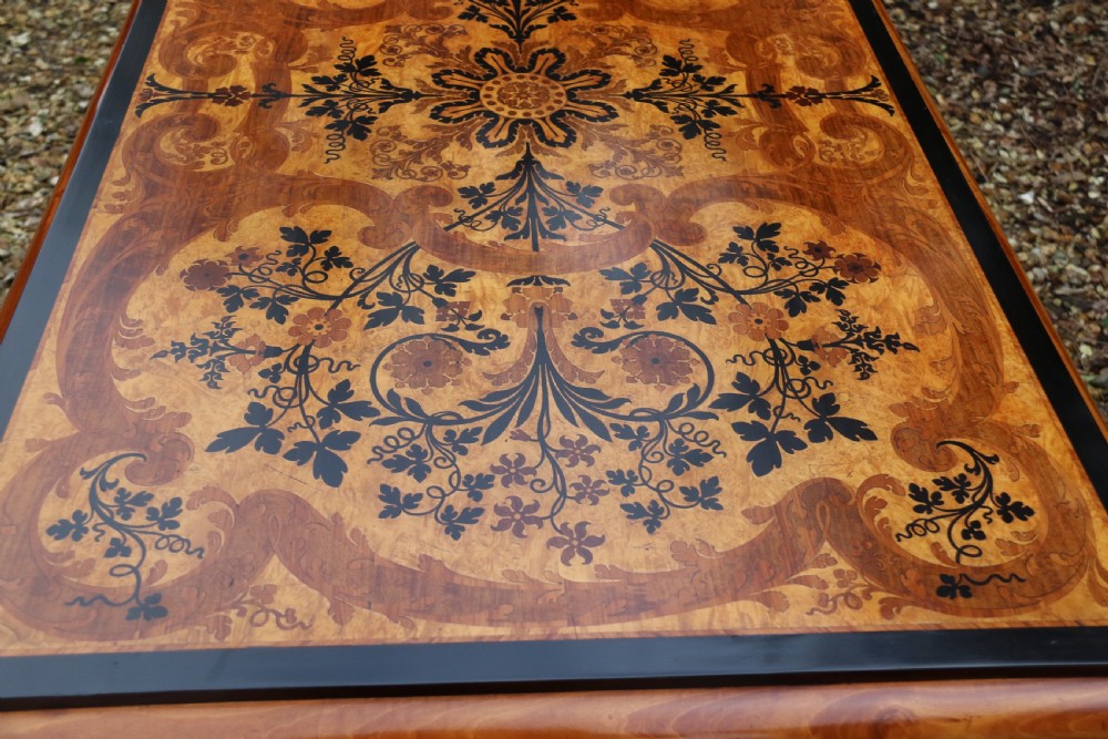 A rectangular mid-19th century satinwood centre table featuring detailed floral marquetry inlay across the tabletop, supported by carved barley twist legs and a central stretcher. View XVIII