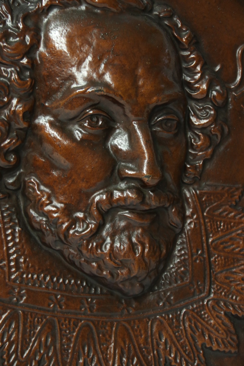 A matched pair of circular dark brown cast iron relief plaques featuring high-relief portrait busts of Peter Paul Rubens and William Shakespeare. View V