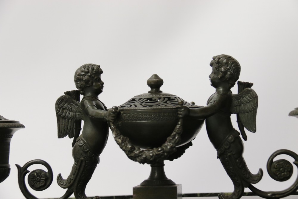 An Empire period dark green marble inkstand featuring dark patinated bronze cherub figures, twin urn inkwells, and carved claw feet. View XXIII