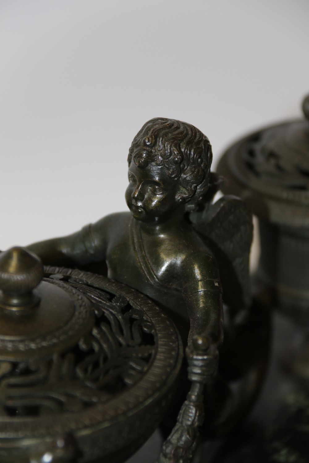 An Empire period dark green marble inkstand featuring dark patinated bronze cherub figures, twin urn inkwells, and carved claw feet. View XXIX