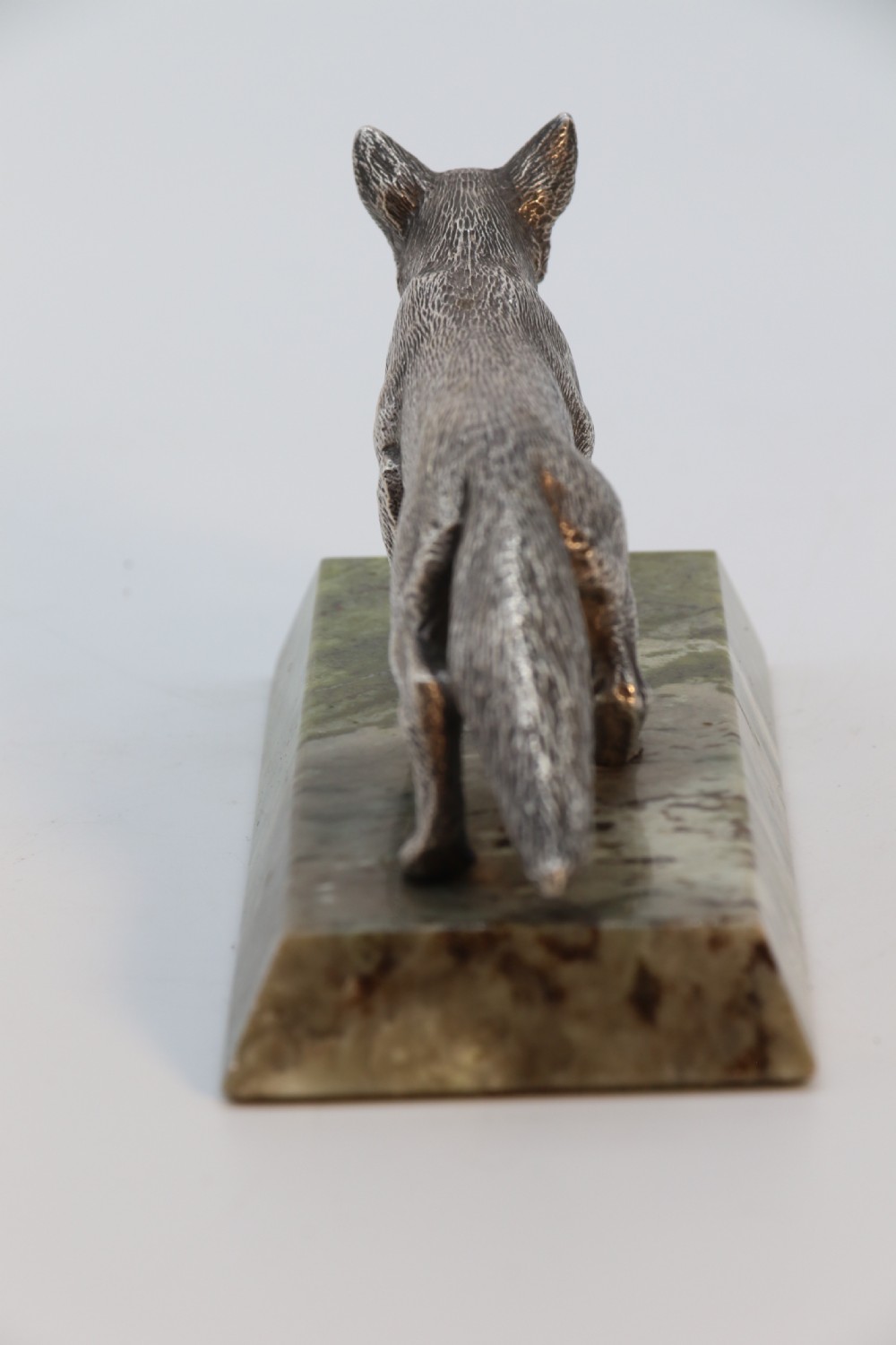 A silvered bronze sculpture depicting a prowling fox mounted on a rectangular green marble plinth. View III