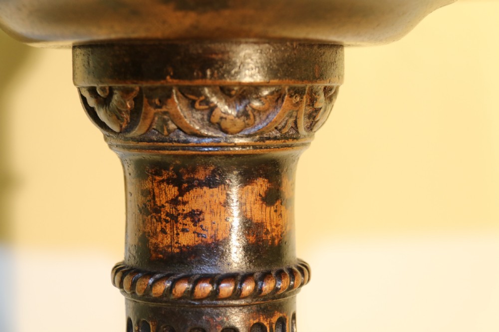 An antique Chippendale mahogany candle stand featuring an octagonal top with a pierced fretwork gallery, a fluted column, and carved tripod legs. View III
