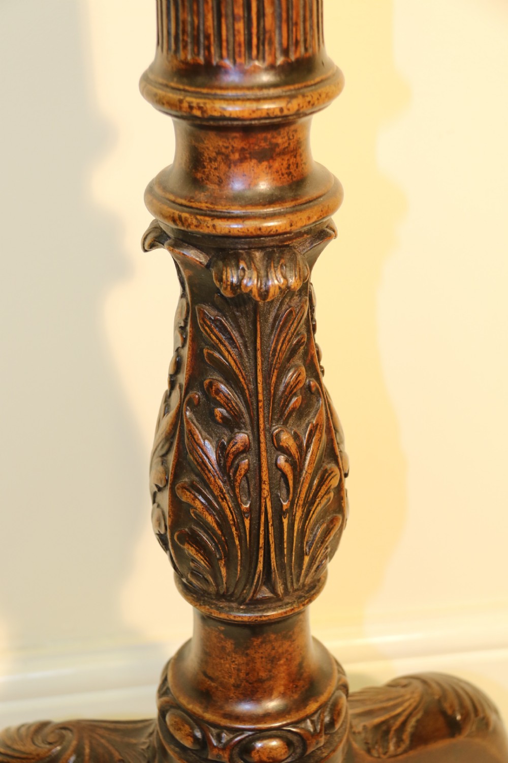 An antique Chippendale mahogany candle stand featuring an octagonal top with a pierced fretwork gallery, a fluted column, and carved tripod legs. View IV