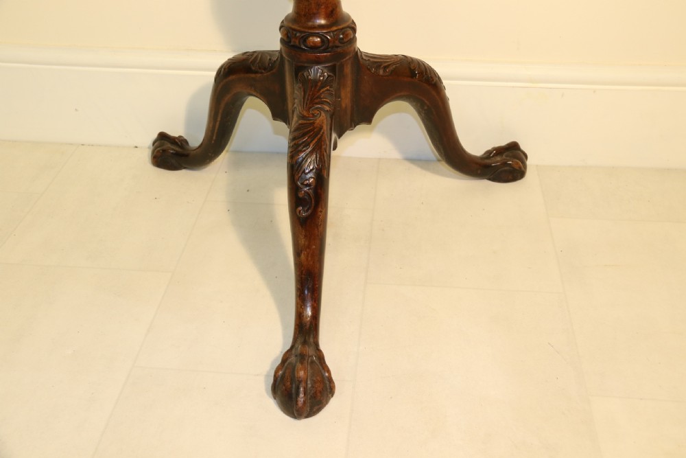 An antique Chippendale mahogany candle stand featuring an octagonal top with a pierced fretwork gallery, a fluted column, and carved tripod legs. View VIII