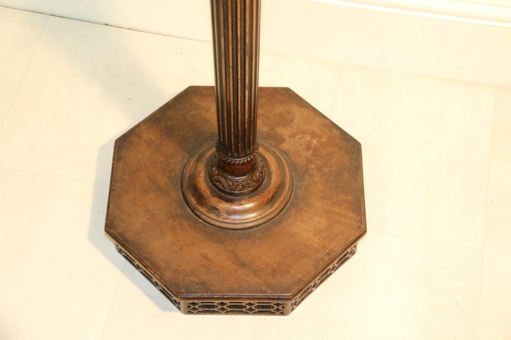 An antique Chippendale mahogany candle stand featuring an octagonal top with a pierced fretwork gallery, a fluted column, and carved tripod legs. View XII