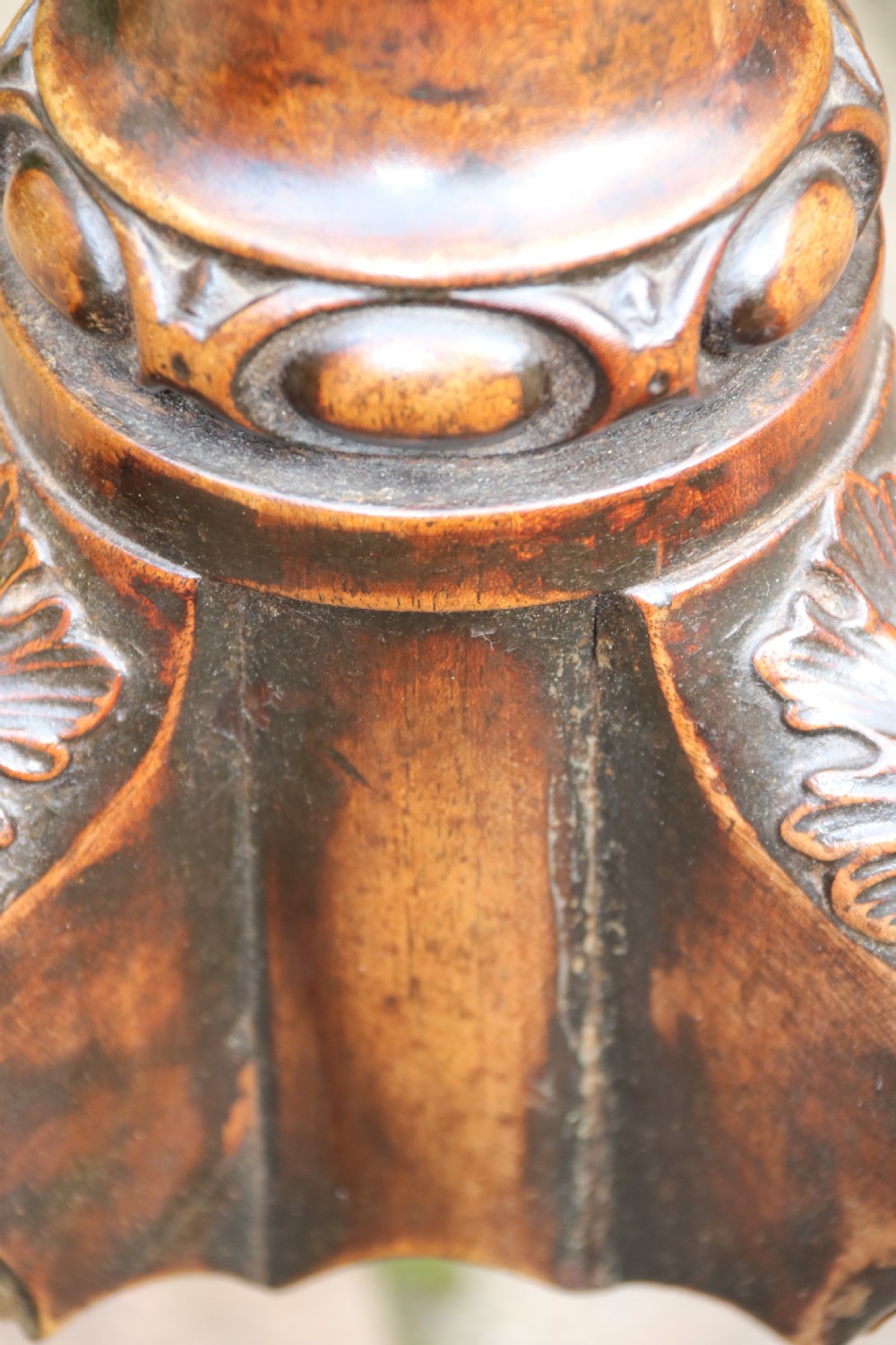 An antique Chippendale mahogany candle stand featuring an octagonal top with a pierced fretwork gallery, a fluted column, and carved tripod legs. View XXII
