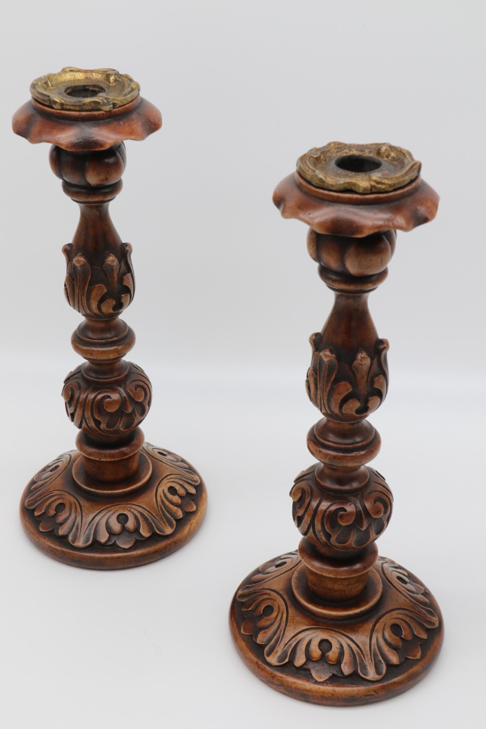 A large scale pair of English 19th century carved walnut and brass mounted candlesticks