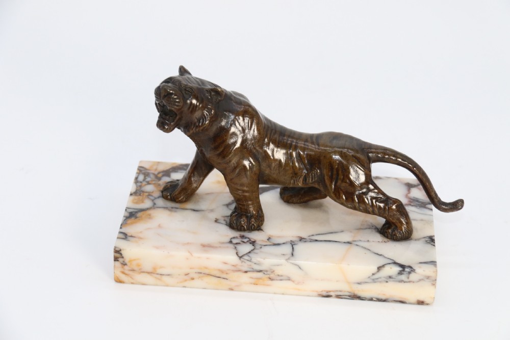 A dark bronze tiger sculpture posed in a roaring stance, mounted on a rectangular veined marble base. View VIII