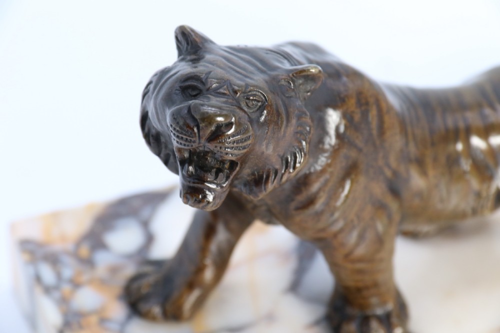 A dark bronze tiger sculpture posed in a roaring stance, mounted on a rectangular veined marble base. View XI